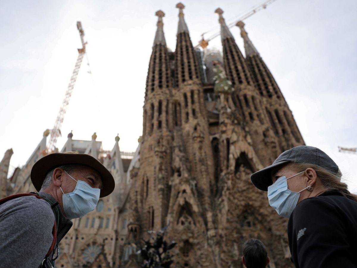 Foto: Turistas con máscaras frente a la Sagrada Familia. (REUTERS)