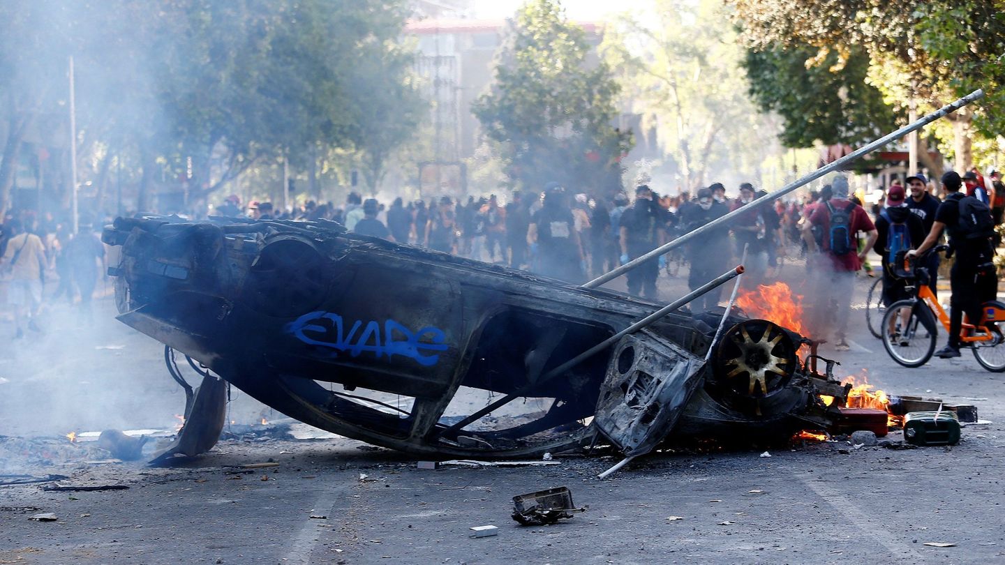 Vista de un vehículo quemado este domingo durante una nueva jornada de protestas en Santiago (Chile). (EFE)