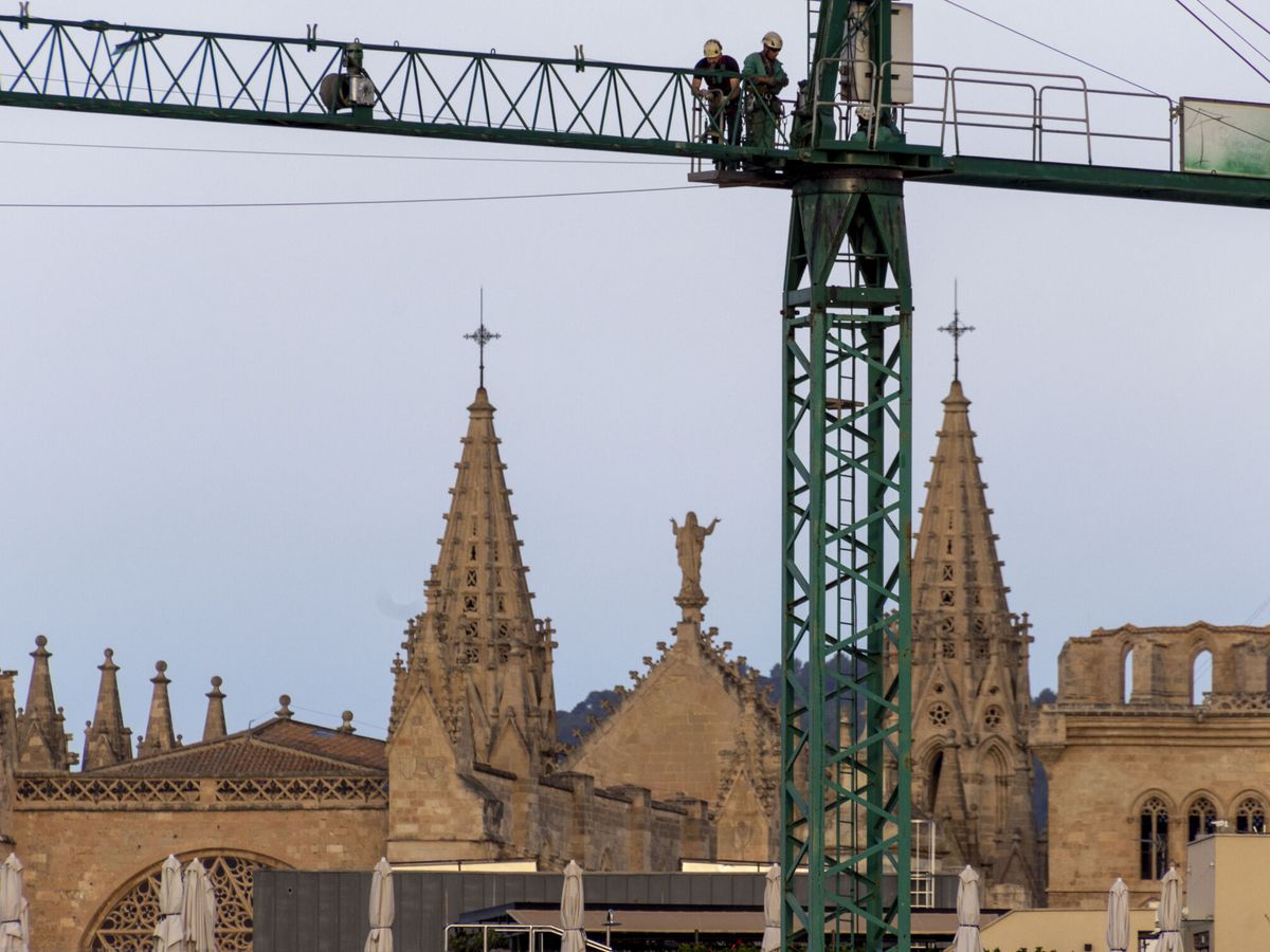 Foto: Trabajadores en una grúa de la construcción en Palma de Mallorca. (Efe) 