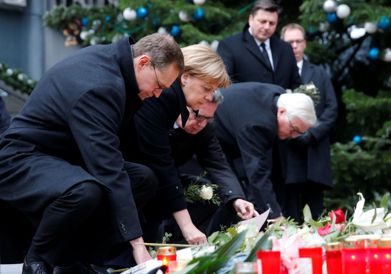 El alcalde de Berlín, Michael Müller, la canciller, Angela Merkel, y los ministros de Interior, Thomas de Maizière, y Exteriores, Frank-Walter Steinmeier, depositan flores en el lugar del atentado. (Reuters)