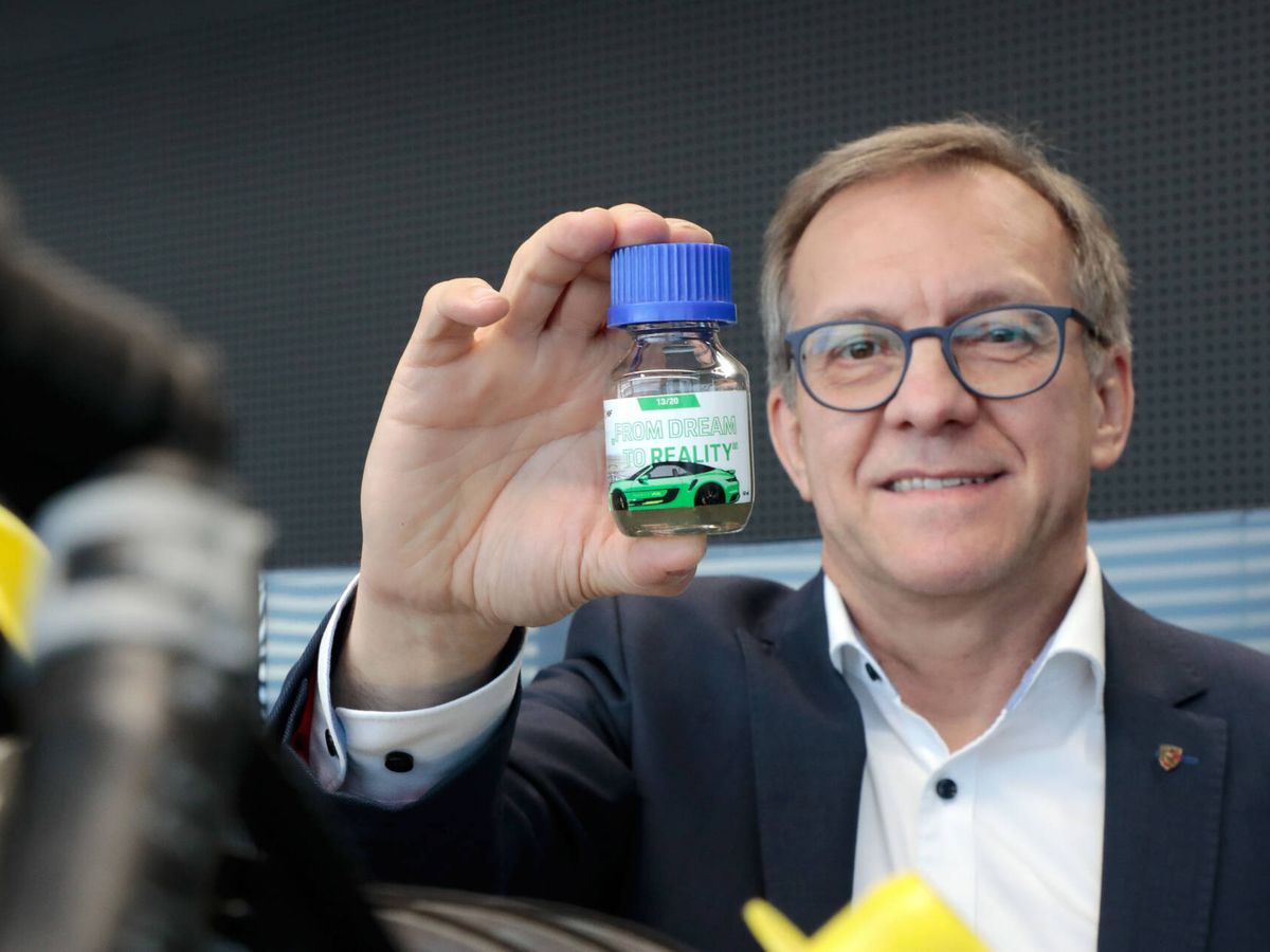 Foto: Karl Dums, de Porsche, sostiene un frasco con e-combustible de la marca. (Porsche)