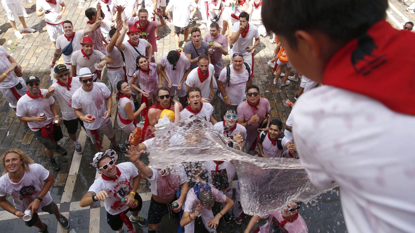 Un grupo de jóvenes sanfermineros reencontrándose con el agua. (EFE/Javier Lizón)