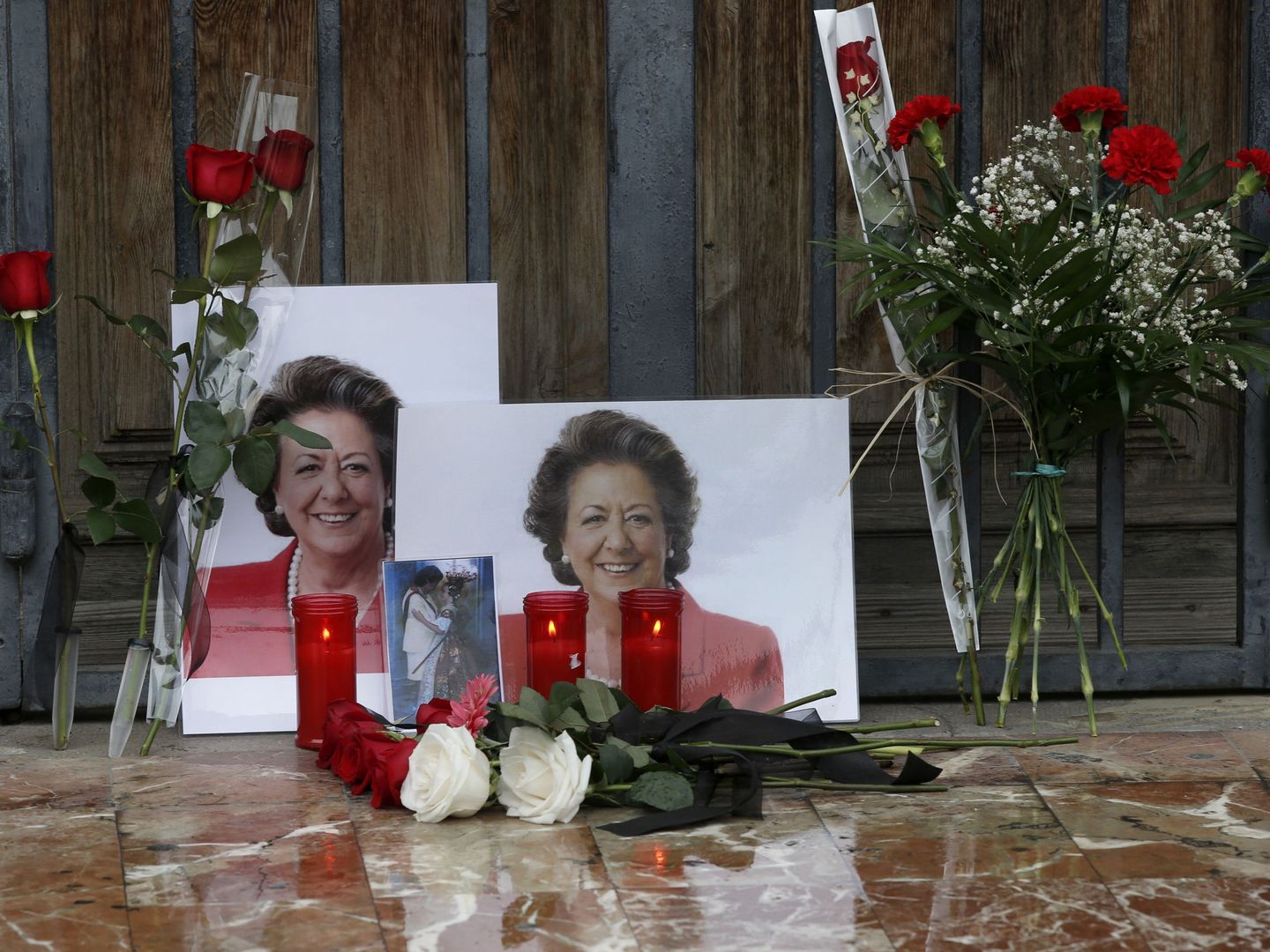Flores y velas en homenaje a Rita Barberá a las puertas del Ayuntamiento de Valencia, que gobernó durante 25 años. (EFE)