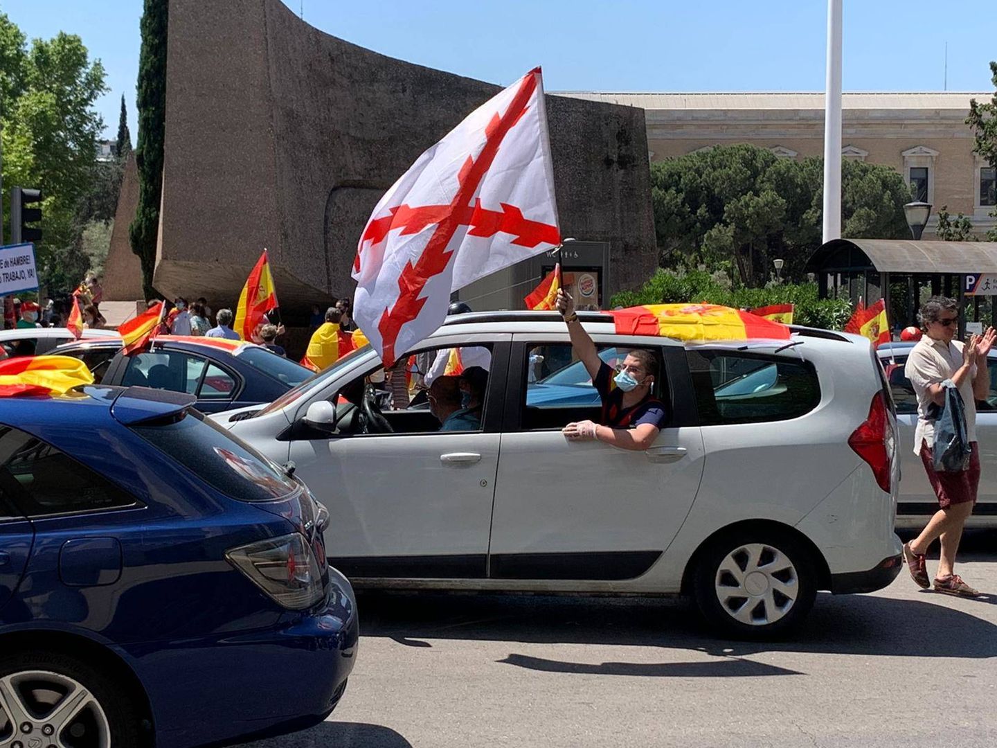 Un manifestante con una bandera con la Cruz de Borgoña, en la madrileña Plaza de Colón. (P. G.)