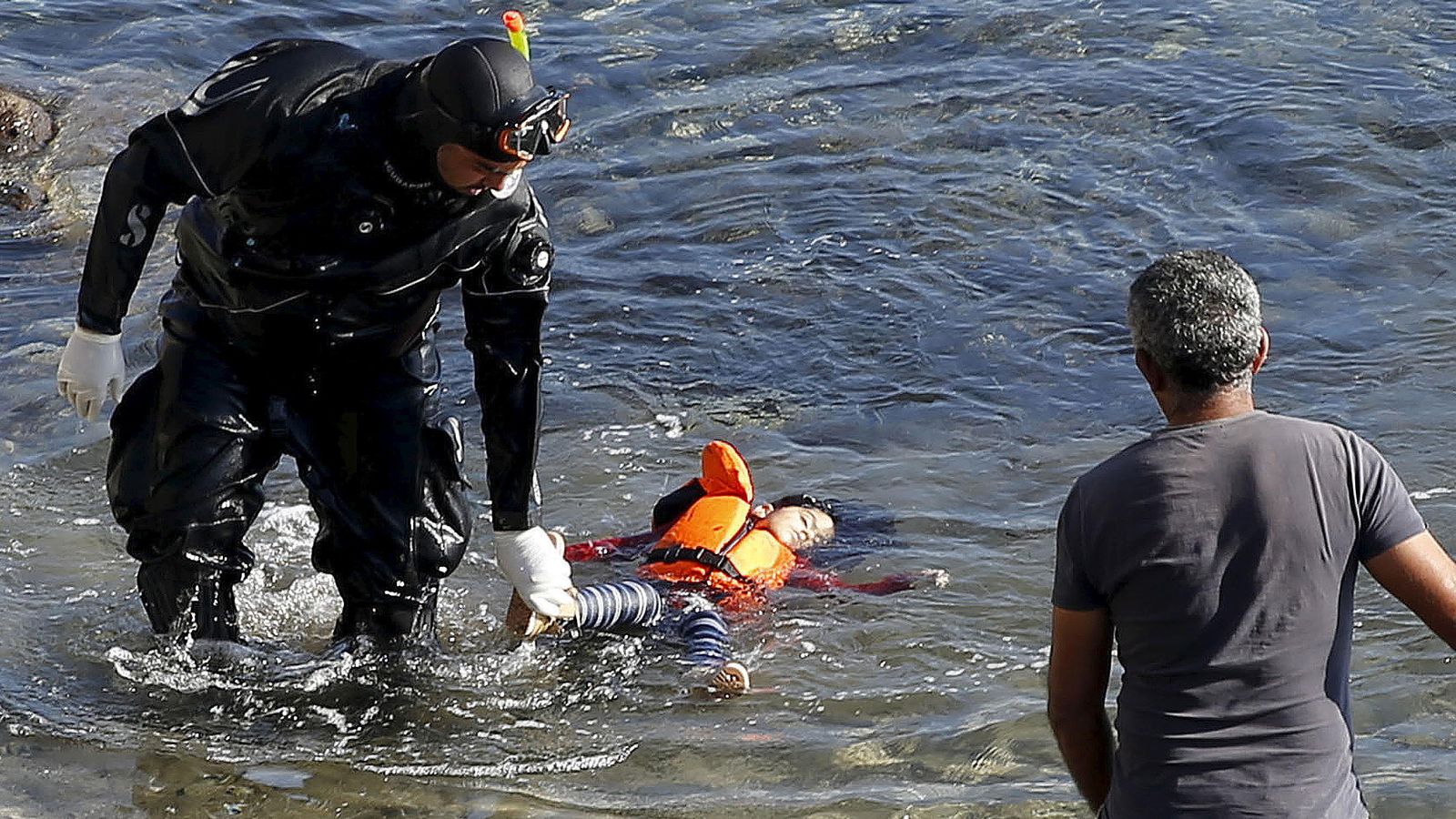 Foto: Un guardacostas griego sostiene el cadáver de una niña en las costas de la isla griega de Lesbos, el 15 de octubre de 2015 (Reuters). 
