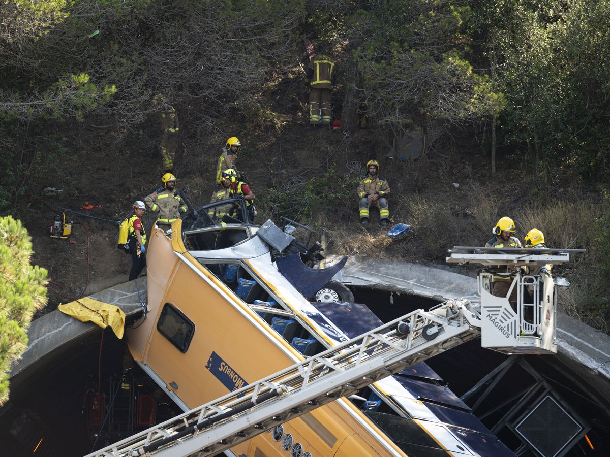 Foto: Sobre las tres de la tarde el cuerpo de bomberos consiguió descolgar del túnel el autobús accidentado. (EFE/David Borrat)
