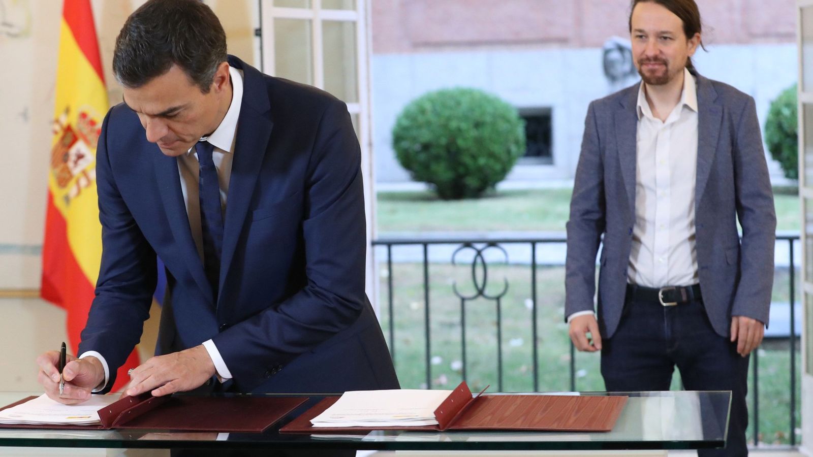 Foto: El presidente del Gobierno, Pedro Sánchez (i), y el secretario general de Podemos, Pablo Iglesias, durante la firma del acuerdo presupuestario en Moncloa. (EFE)