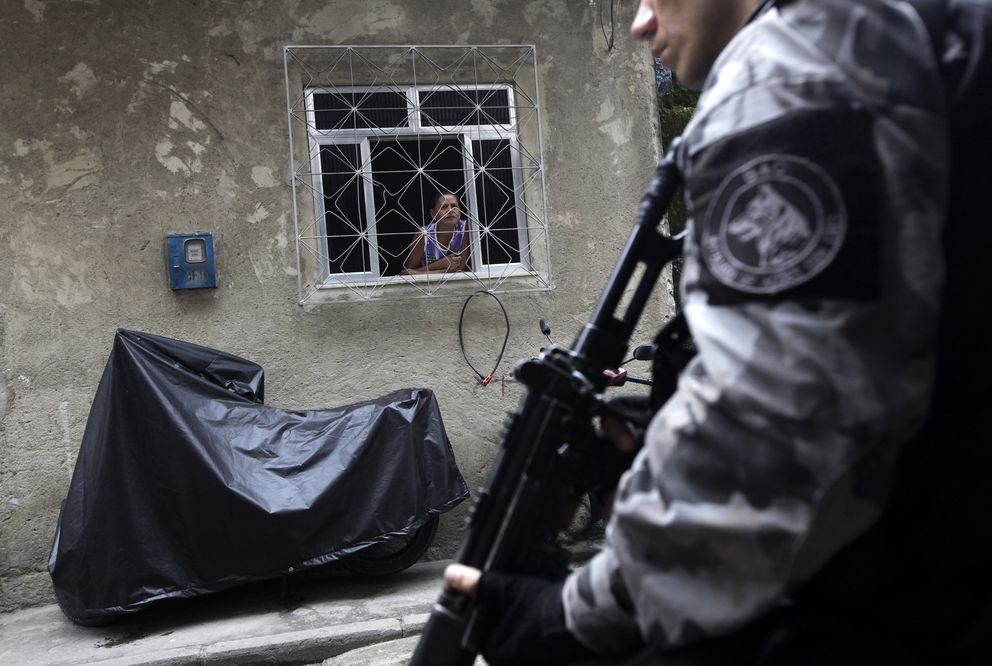 Una residente de la favela la Maré, en Río, observa a un agente (Reuters). 