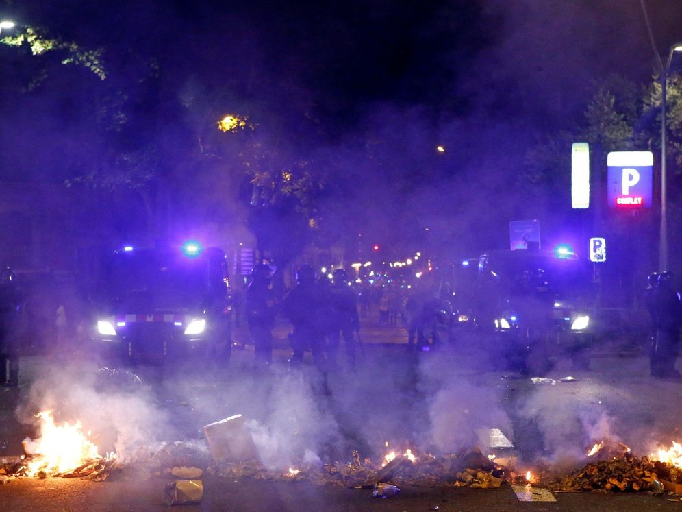 Foto: Mossos d'esquadra ante una barricada de fuego en Paseo de Gracia. (EFE)