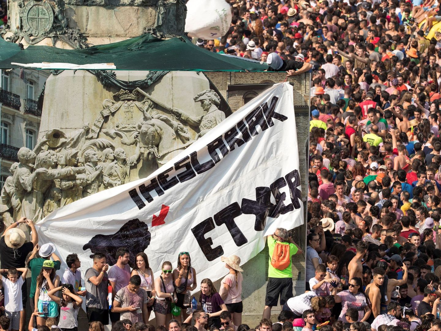 Un grupo de encapuchados colocan pancartas de apoyo a los presos de ETA durante el inicio de las fiestas de la Vitoria. (EFE)