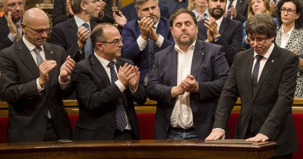 Foto: El presidente de la Generalitat, Carles Puigdemont (d), recibe el aplauso de los miembros del Govern tras su comparecencia. (EFE)