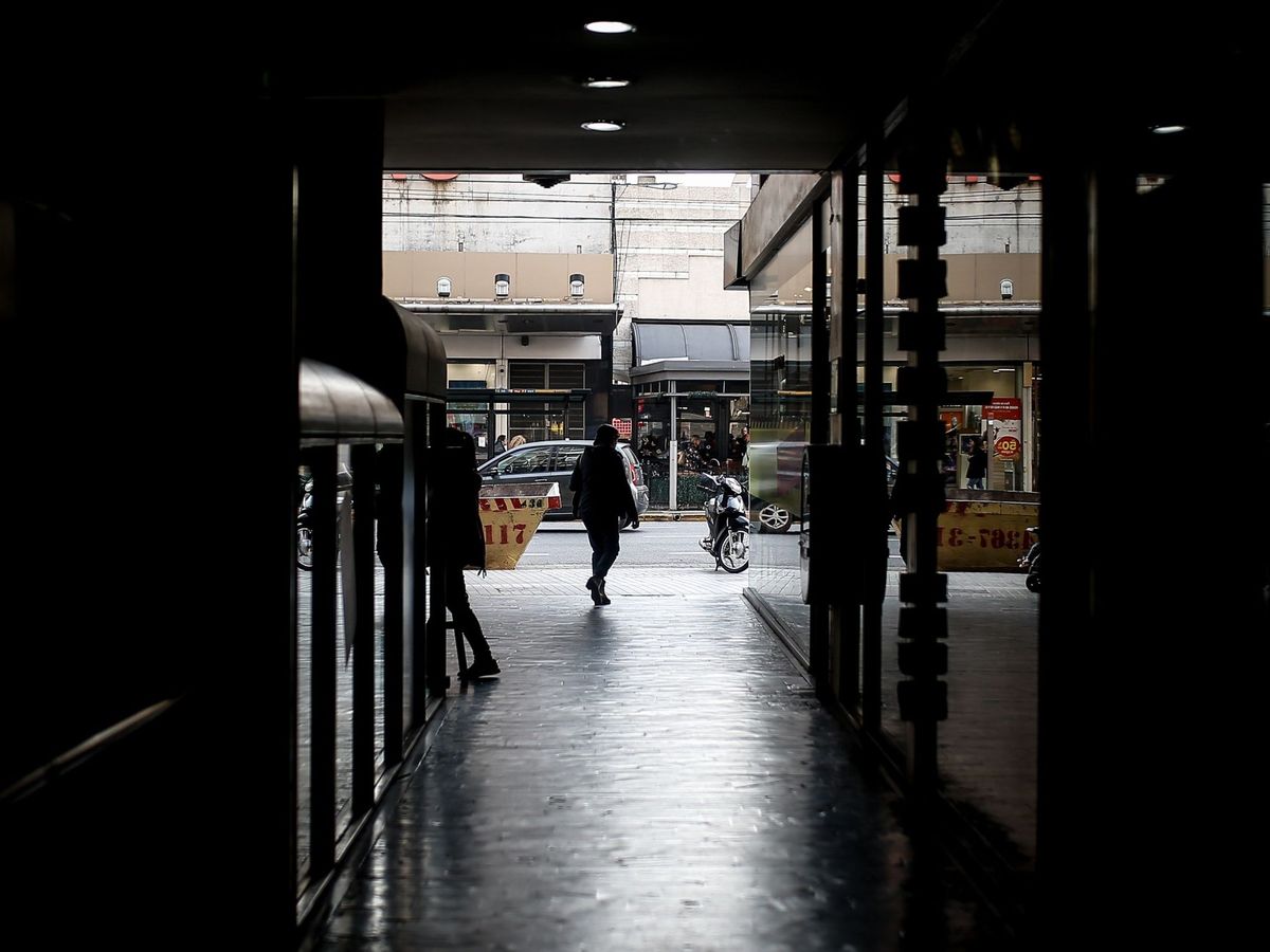 Foto: Una persona circula por un centro comercial cuyas tiendas permanecen cerradas. (EFE)