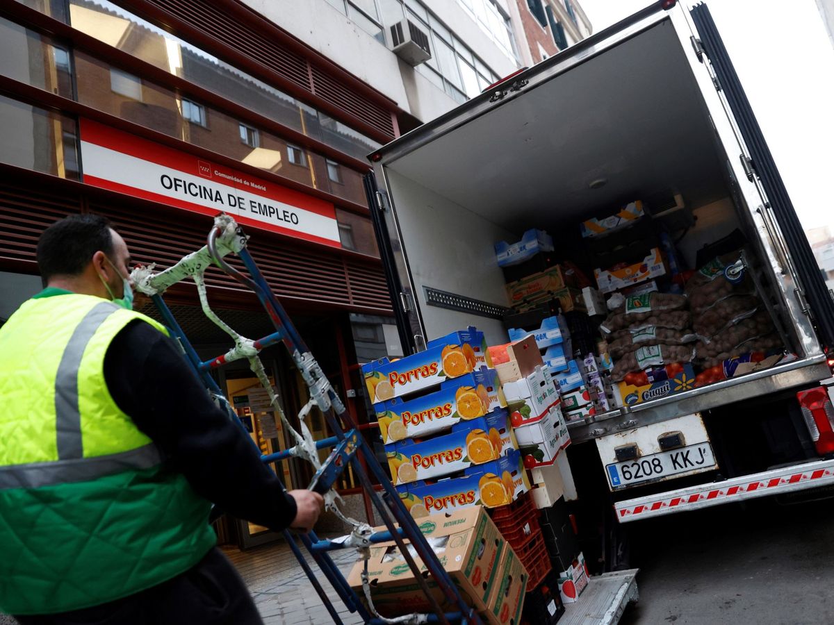 Foto: Un operario descarga la mercancía de un camión junto una oficina de empleo en Madrid. (EFE/Mariscal)
