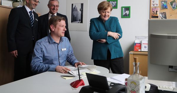 Foto: La canciller alemana, Angela Merkel (d), habla con los trabajadores de una oficina de empleo. (EFE)