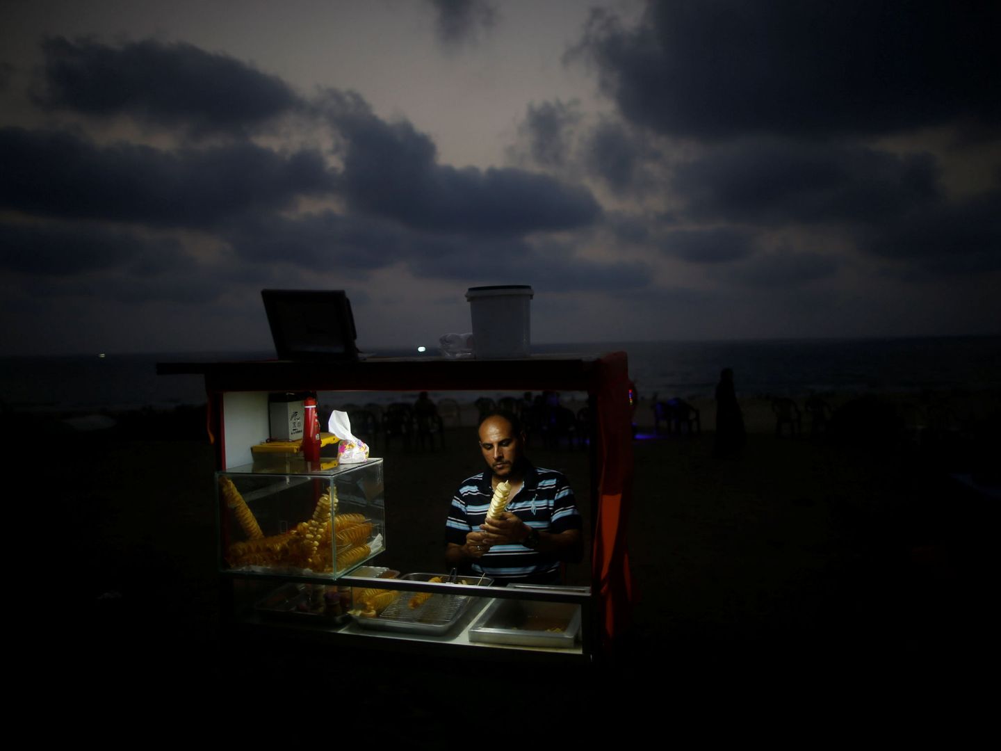 Un palestino vende sándwiches durante un corte de luz en Gaza, el 12 de julio de 2017. (Reuters)