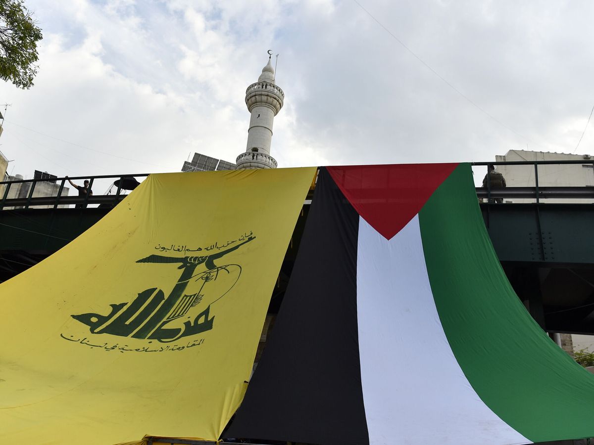 Foto: Las banderas de Hezbolá y Palestina cuelgan de un puente durante una protesta en solidaridad con los palestinos, en Beirut. (EFE/Wael Hamzeh)