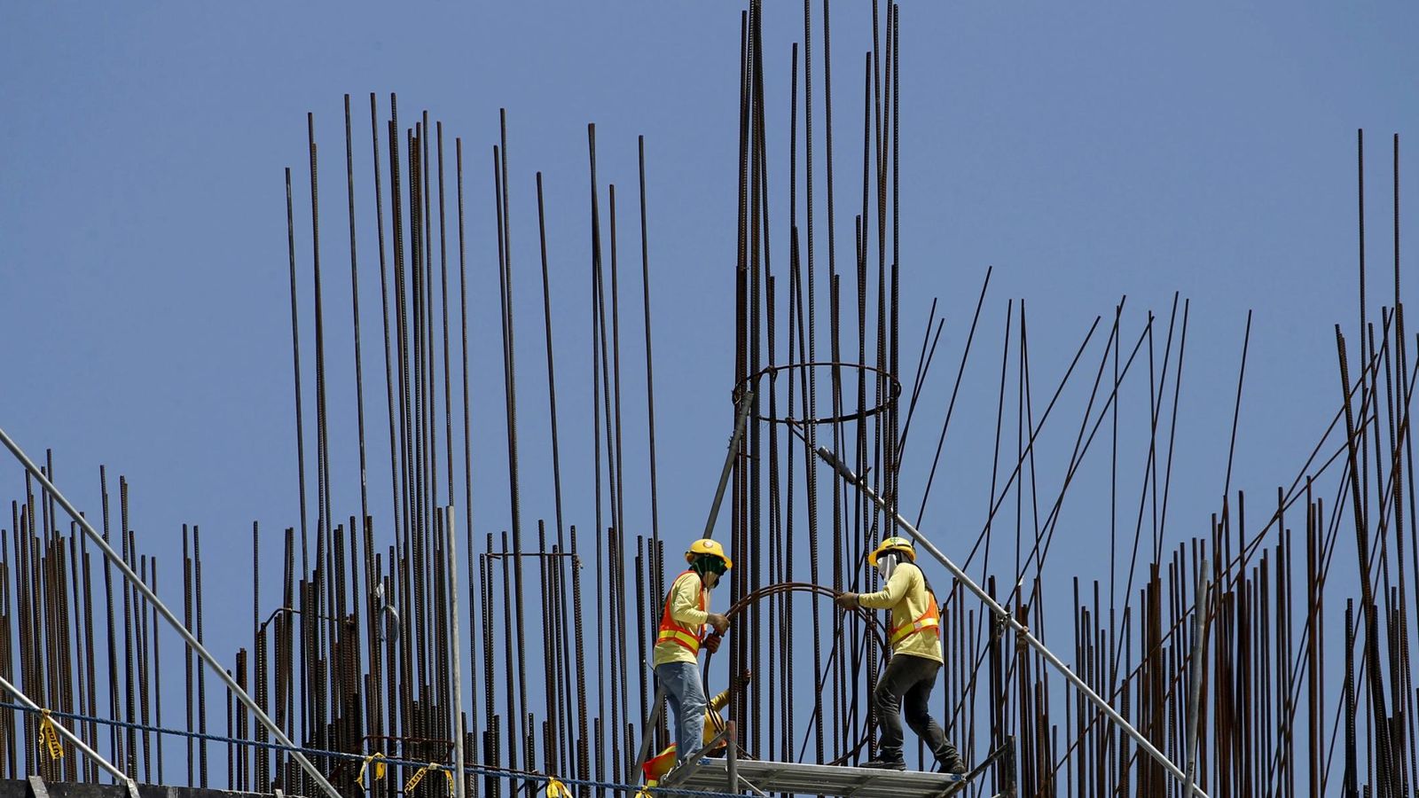 Foto: Varios trabajadores construyen un edificio. (Reuters)