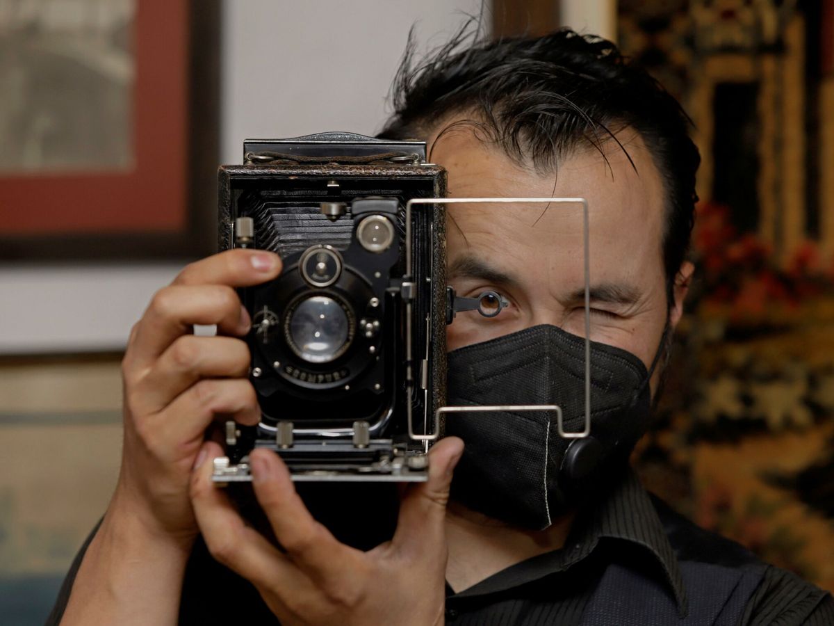 Foto: Domenikos Ruiz, coleccionista de 3.000 cámaras fotográficas, posa con una de ellas.  (Hilda Ríos/EFE)