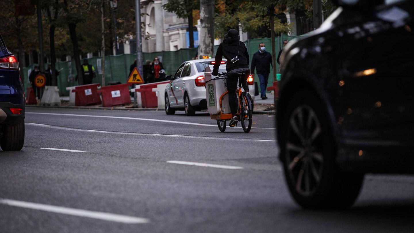 Varios coches y una bicicleta recorren el Paseo del Prado. (Alejandro Martínez Vélez)