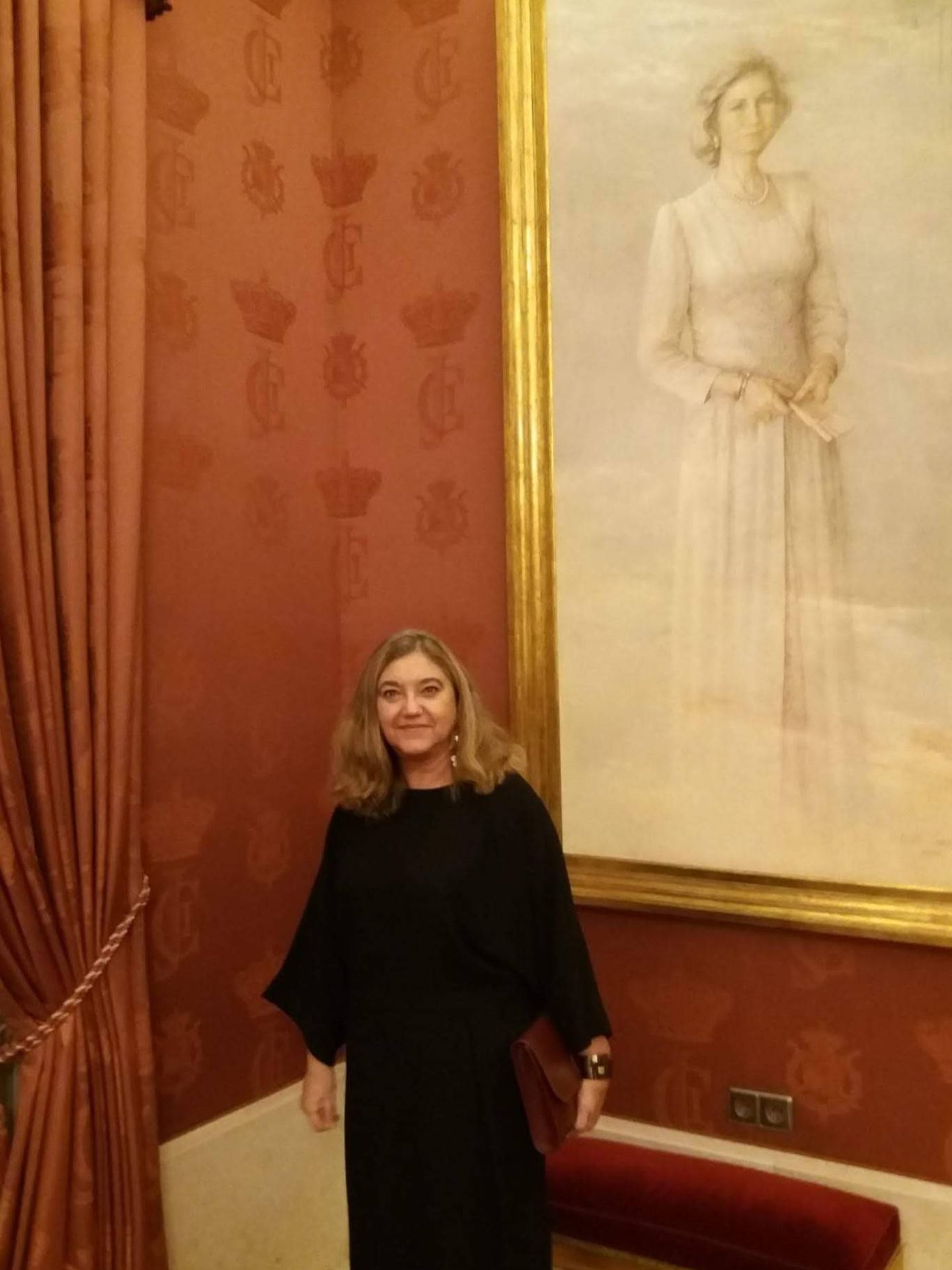 La autora, junto a un retrato de la reina Sofía. (Foto cedida)