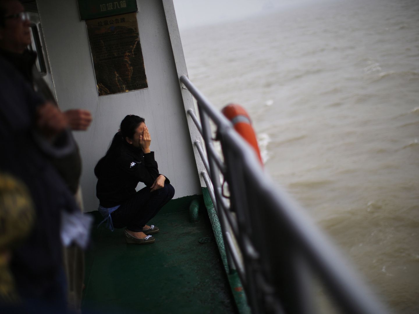 Una mujer llora durante un entierro en el mar en Shanghái, China (Reuters).