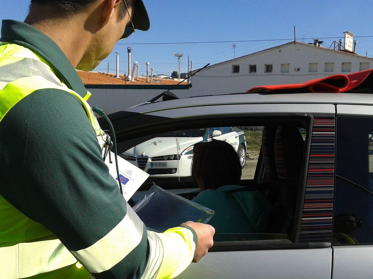 Foto: Agente de la DGT revisando la documentación de un conductor y de su vehículo. 