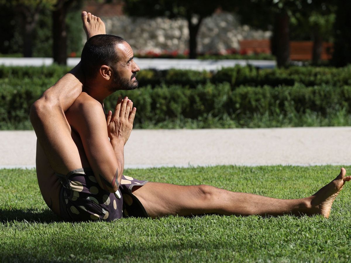 Foto: Un hombre practica yoga en El Retiro durante un día del pasado mes de agosto. (EFE/Mariscal)
