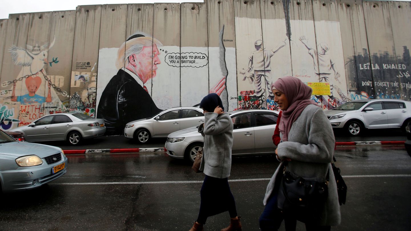 Palestinas pasan ante una pintada contra Donald Trump en Belén, Cisjordania. (Reuters)