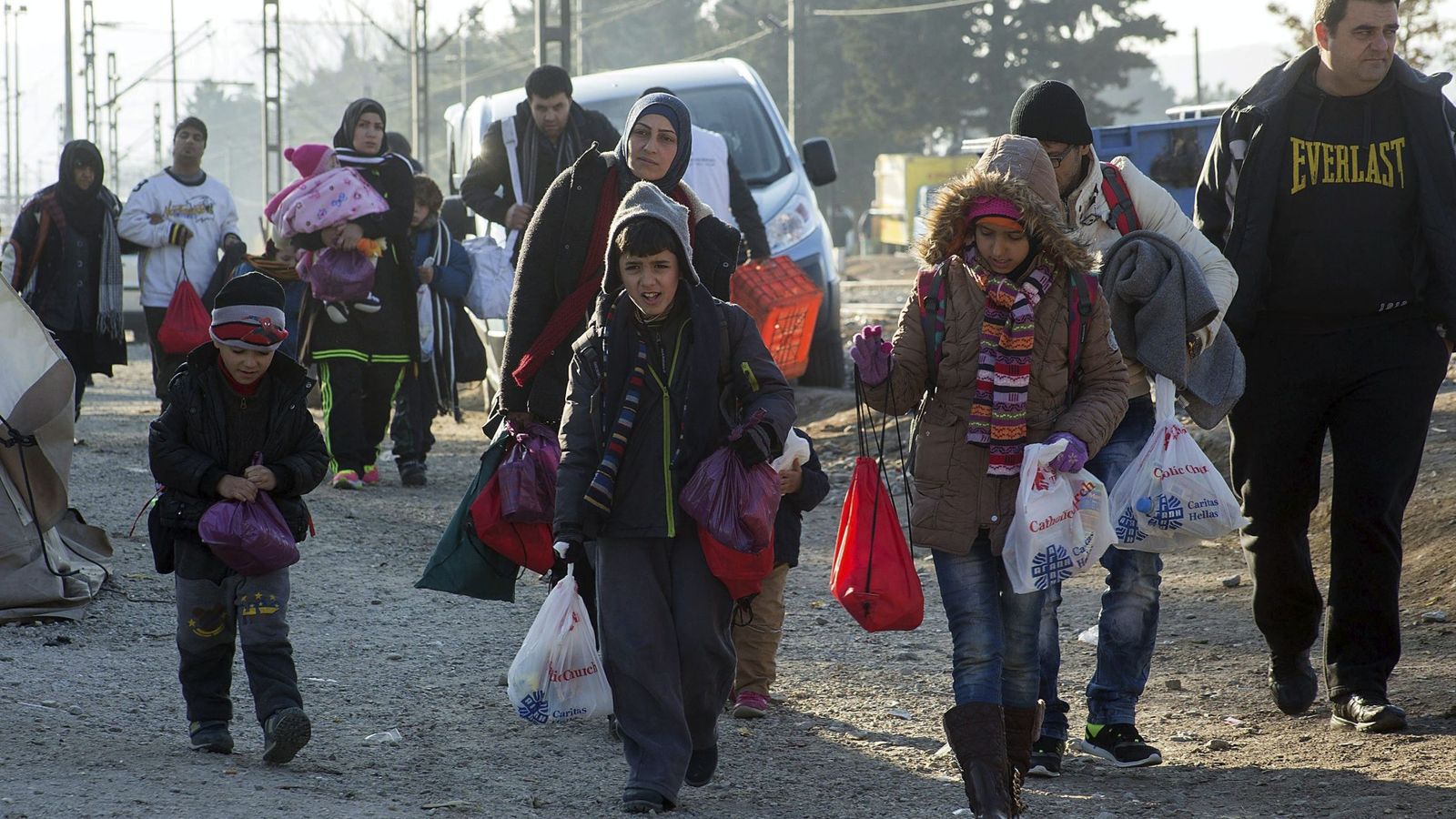 Foto: Un grupo de refugiados se dirige a cruzar la frontera entre Grecia y Macedonia este viernes. (EFE)