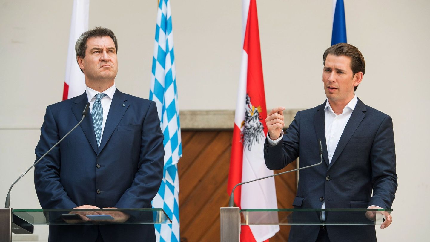 El primer ministro del estado de Baviera, Markus Söder (i), y el canciller austriaco, Sebastian Kurz (d). El damero azul y blanco es la bandera de Baviera. (EFE)