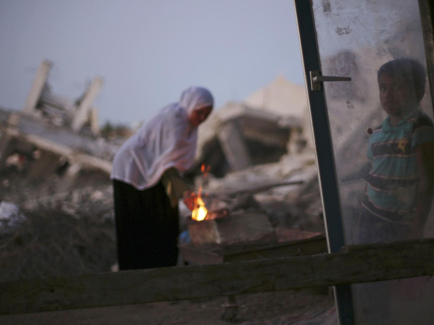 Una palestina prepara café cerca de su casa reducida a escombros en Al Mughraga (Reuters).
