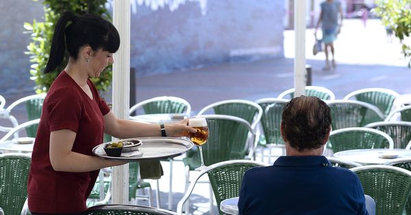 Foto: Una camarera sirve una consumición en una terraza. (EFE)
