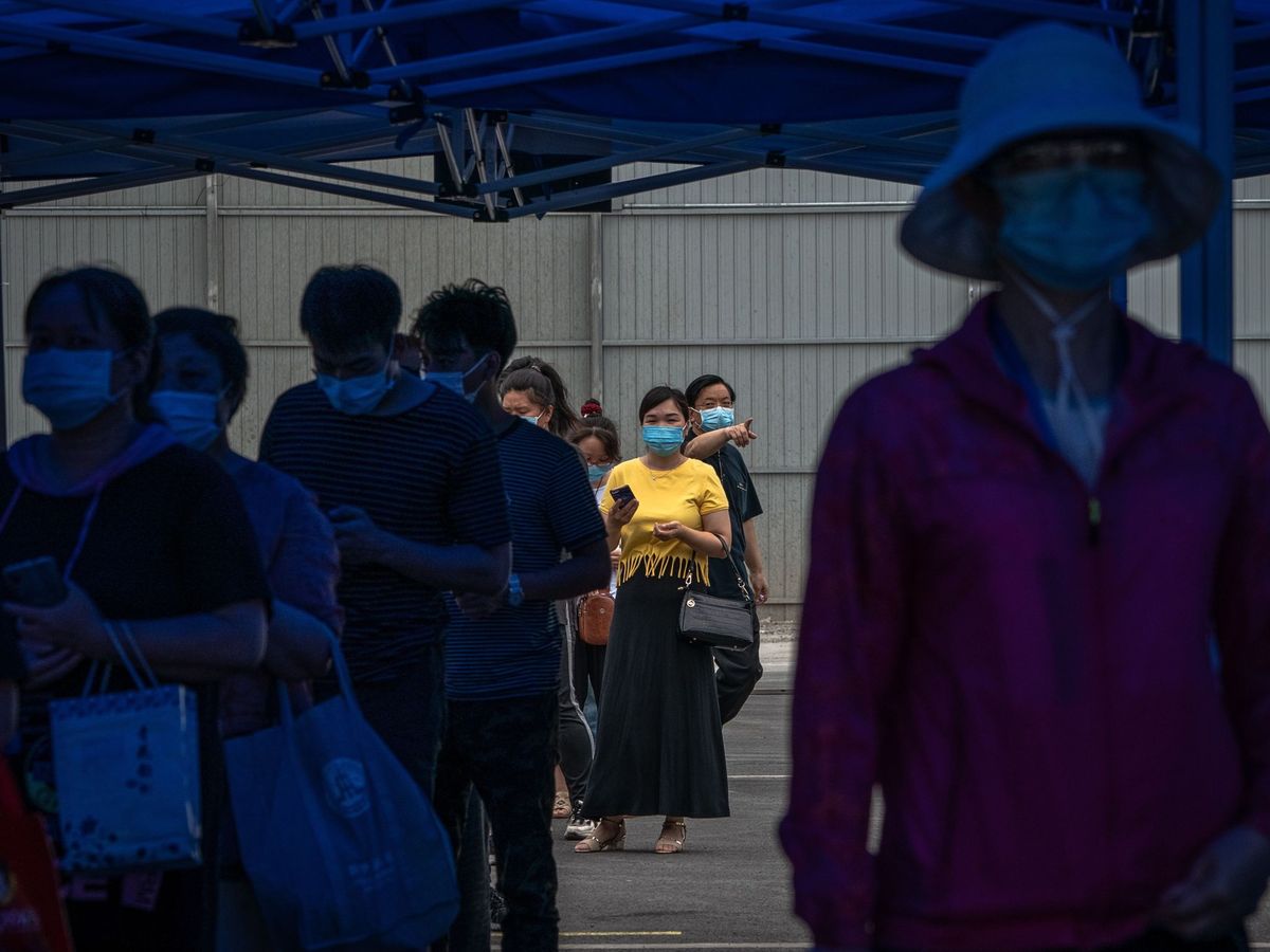 Foto: Una cola de ciudadanos chinos en Pekín espera para someterse a una prueba del covid-19, el pasado día 24. (EFE)