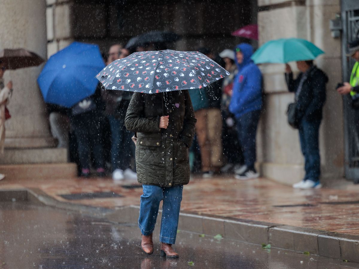 Foto: Vista de personas bajo la lluvia. (EFE/Biel Aliño)