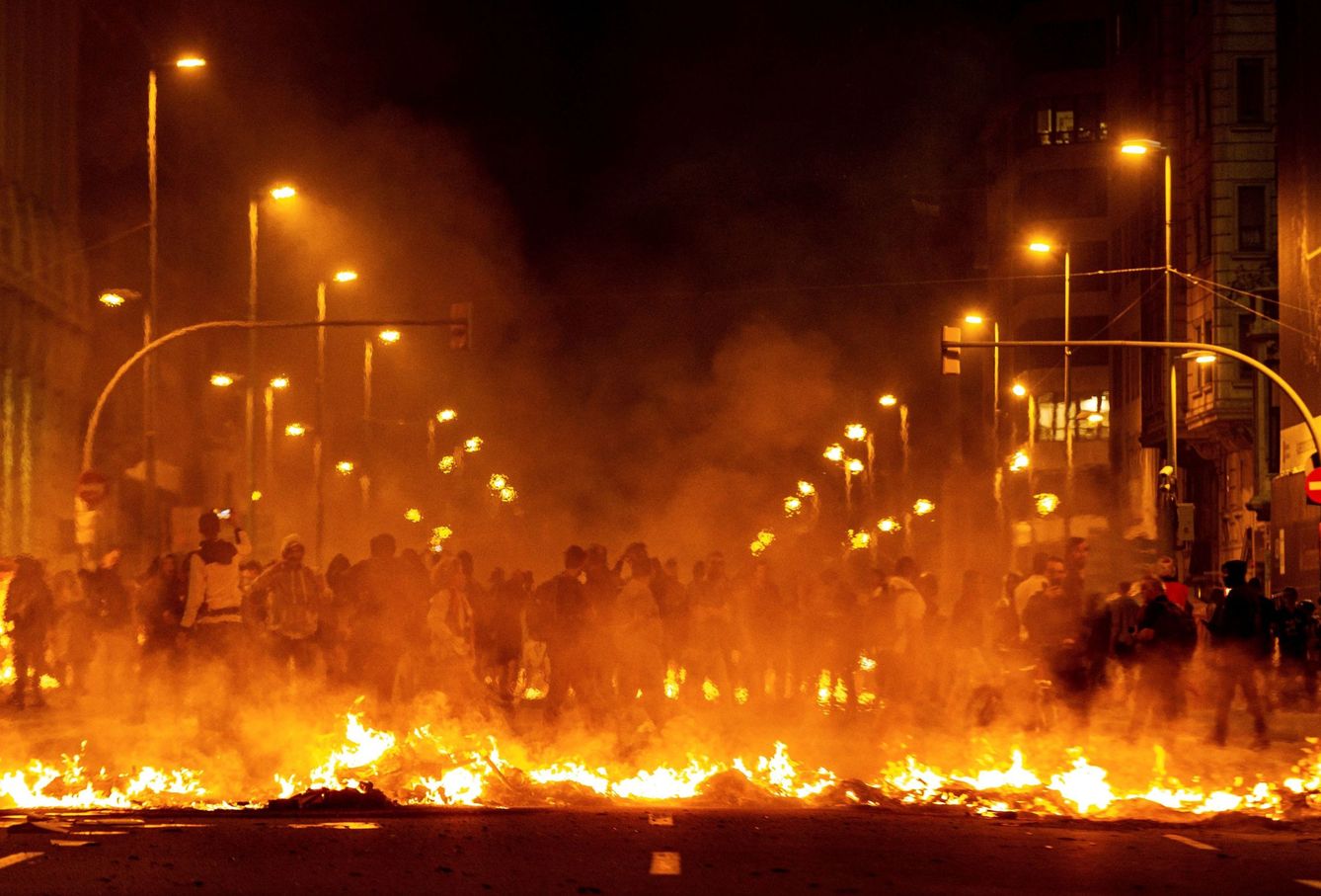 Los manifestantes incendian cartones junto a la Delegación del Gobierno en Barcelona. (EFE)