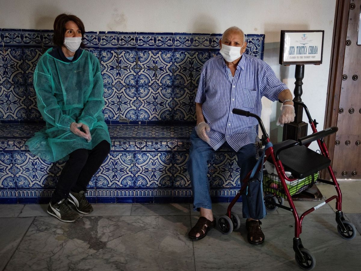 Foto: Un residente del Hospital de la Caridad de Sevilla junto a un familiar. (EFE)