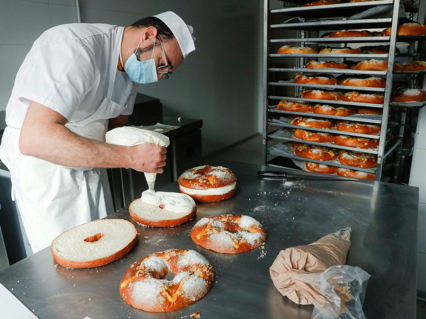 Un pastelero prepara coronas de la Almudena en la pastelería La Mallorquina en Madrid. (EFE/Emilio Naranjo)