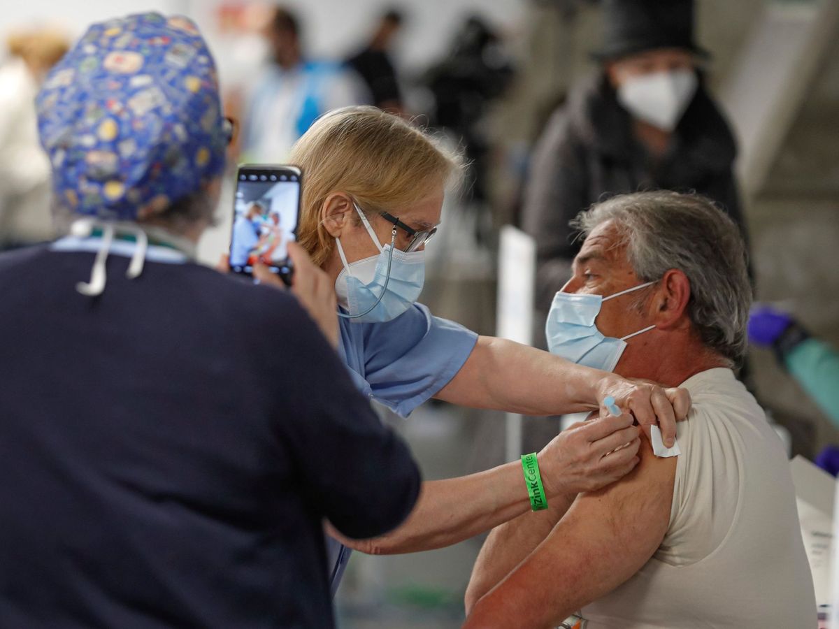 Foto: Un hombre recibe la vacuna en el WiZink Center. (EFE)