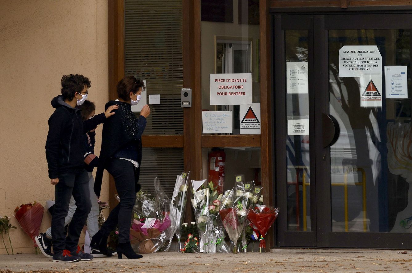 Padres y alumnos dejan flores en la puerta del instituto en el que trabajaba el profesor asesinado. (EFE)