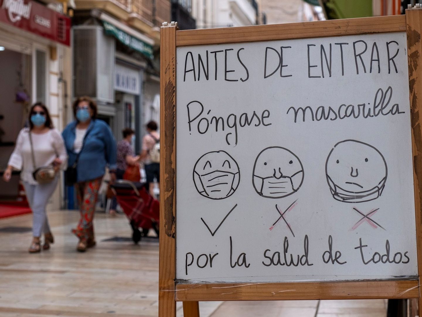 Un cartel a la entrada de un establecimiento de Huelva informa a los clientes de la obligatoriedad del uso de mascarillas. (EFE)