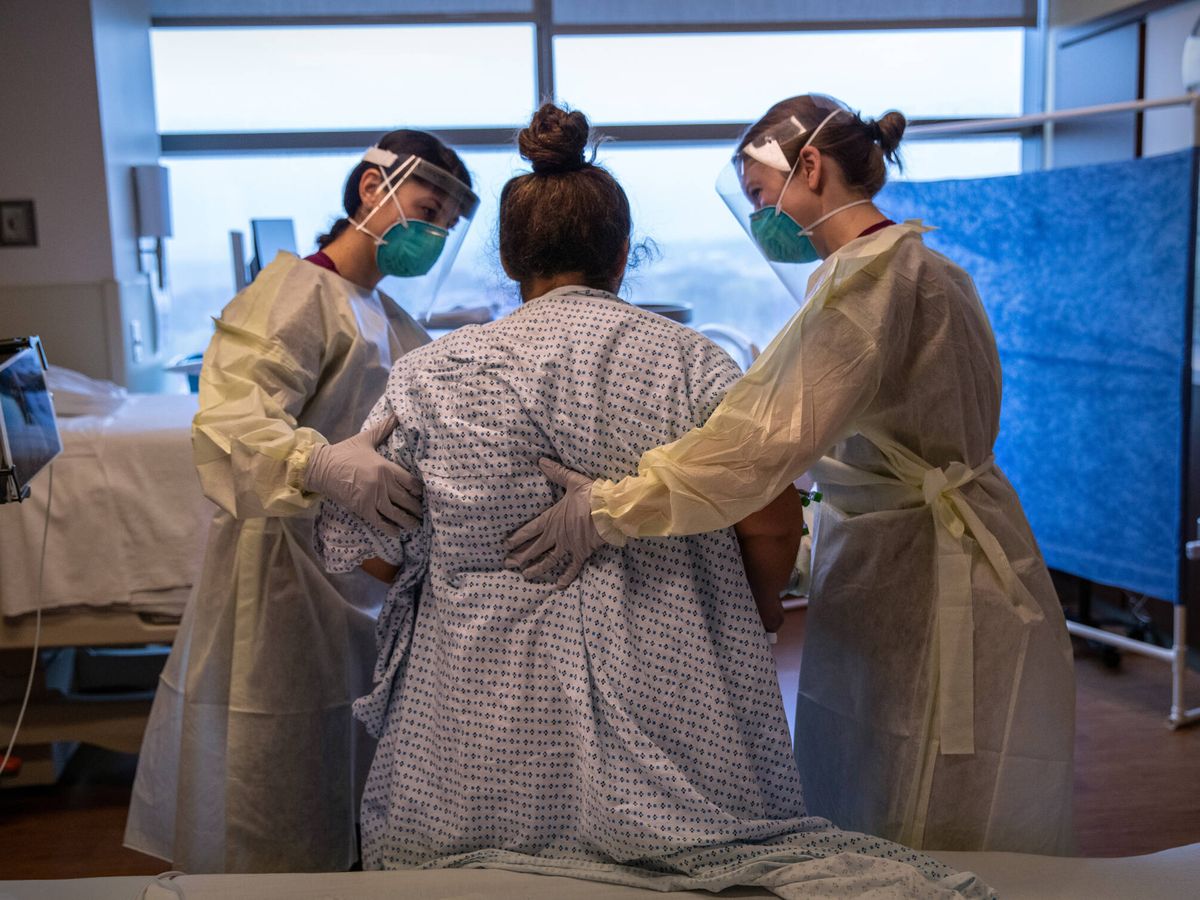 Foto: Dos enfermeras asisten a una mujer a punto de dar a luz. (Getty)