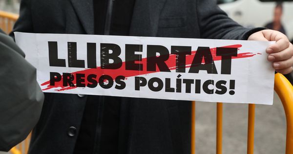 Foto: Un hombre sostiene un cartel con el lema "Libertat presos polítics" a las puertas del Tribunal Supremo. (EFE)