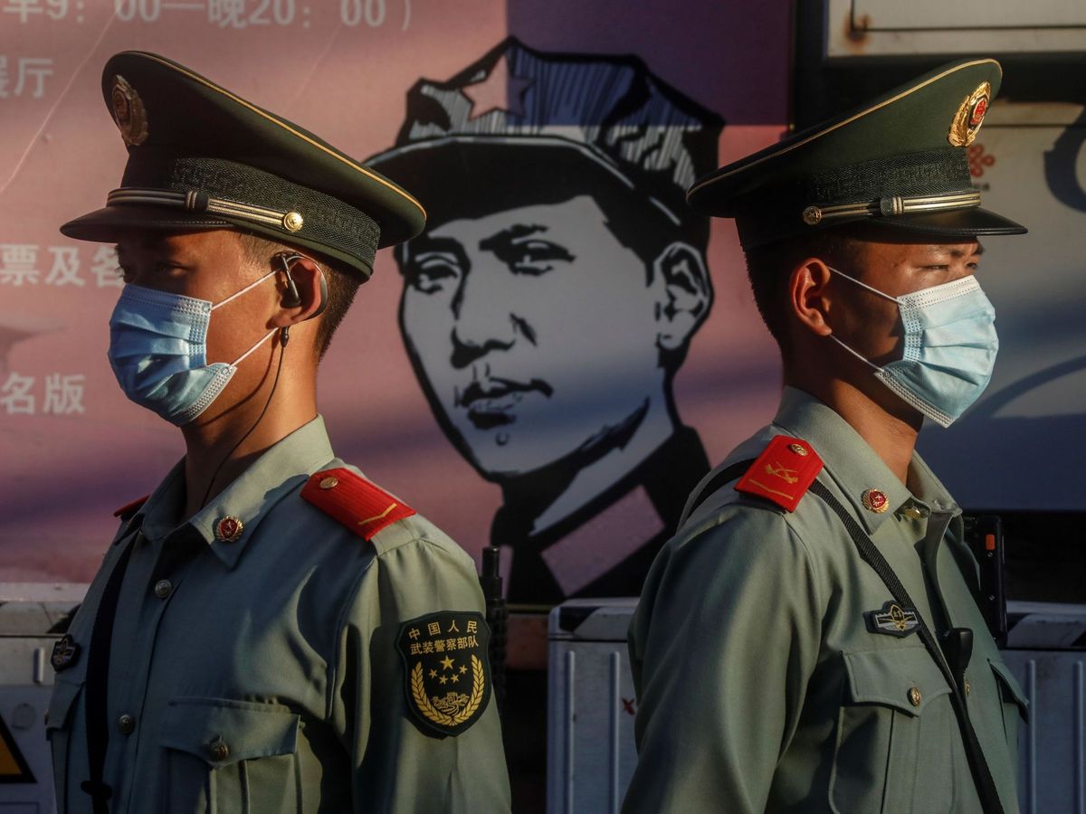 Foto: Agentes de la policía paramilitar china montan guardia frente a un retrato del fundador de la República Popular China, Mao Zedong, en Pekín. (EFE)