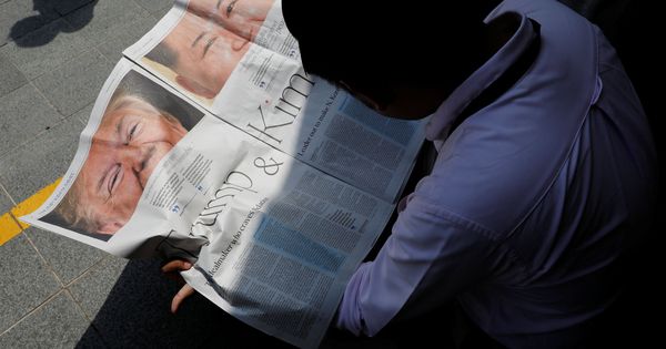 Foto: Un periodista local lee en un diario un artículo sobre el encuentro entre Trump y Kim en Singapur, el 11 de junio de 2018. (Reuters)