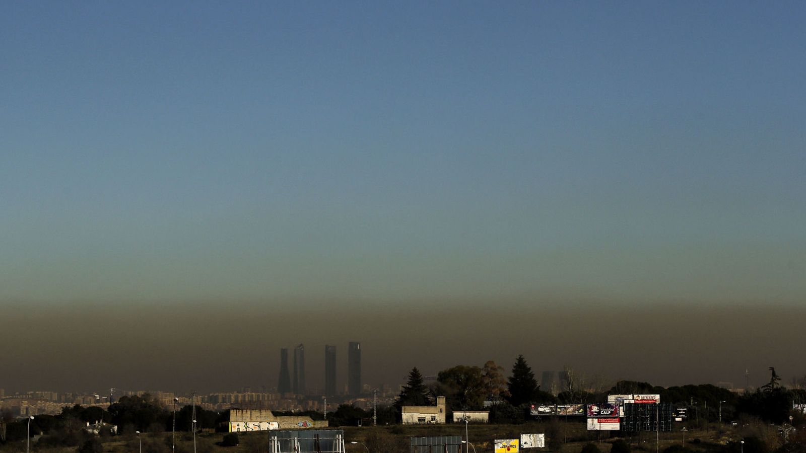 Foto: Vista de las Cuatro Torres de Madrid, con la boina de contaminación que se extiende desde hace unos días sobre la capital, desde Boadilla del Monte, ayer. (EFE)