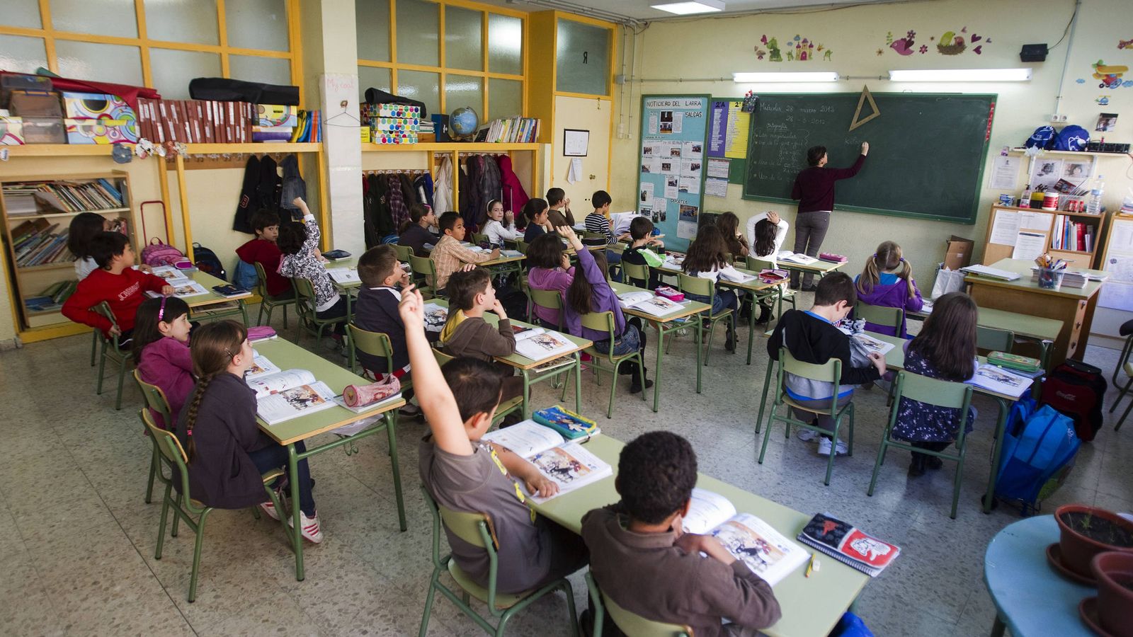 Foto: Una profesora escribe en la pizarra de un colegio público madrileño. (Reuters/Sergio Pérez)