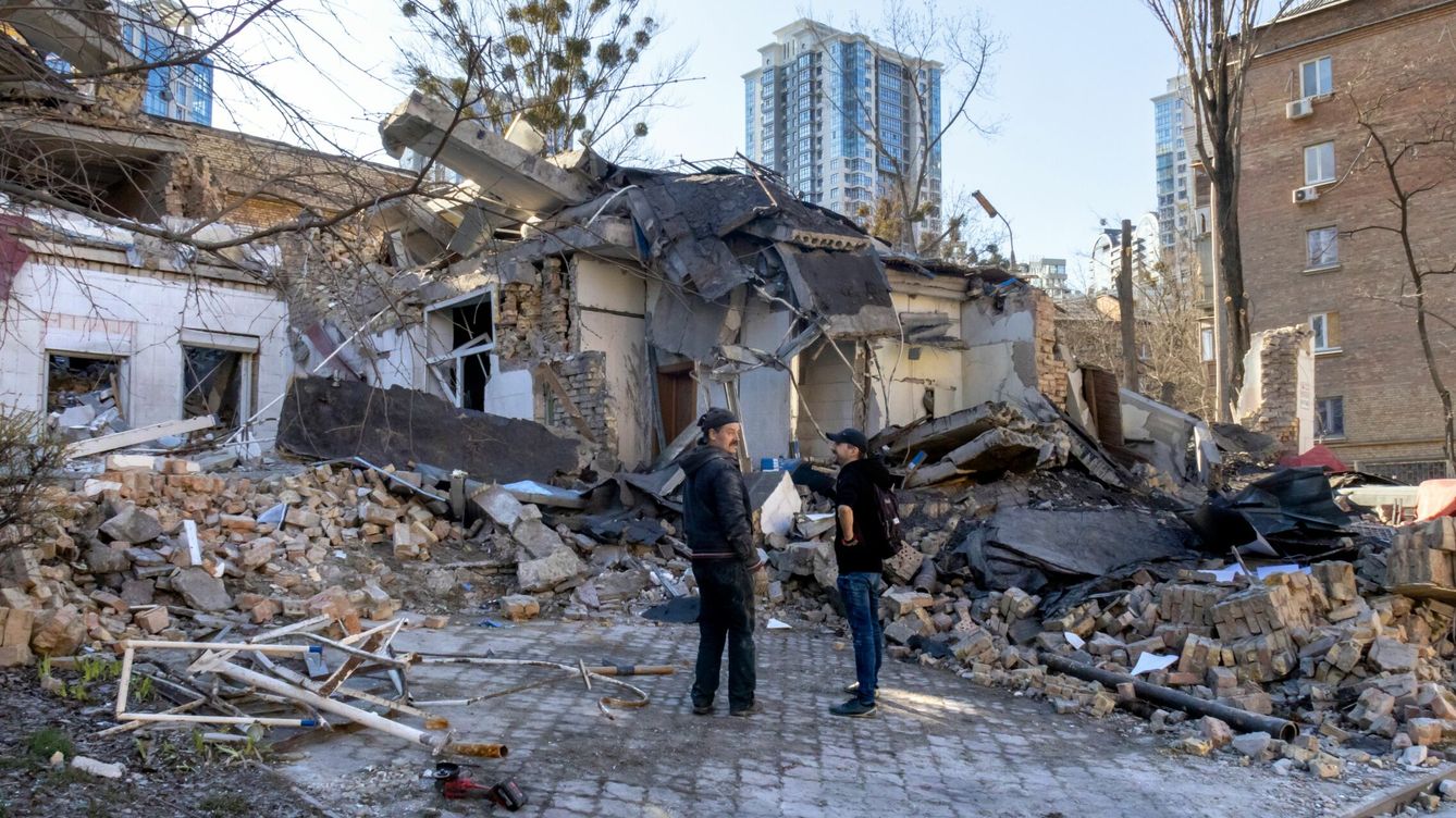 Foto: Dos personas ante un edificio destruido por los ataques en Kiev. (Zuma Press)