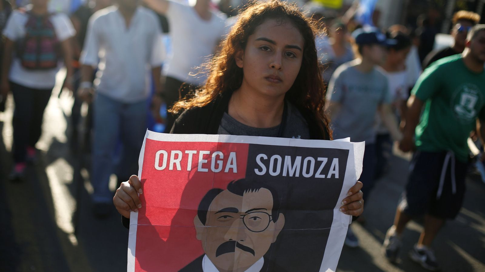 Foto: Una manifestante enarbola un cartel que dice: "Ortega, Somoza, son la misma cosa", durante una marcha en Managua el 23 de abril de 2018. (Reuters)