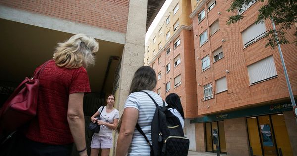 Foto: Un grupo de vecinos conversa en el lugar donde dos niñas de 2 y 6 años han sido asesinadas a cuchilladas por su padre en Castellón. (EFE)