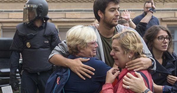 Foto: Varias personas lloran en el exterior del Instituto Can Vilumara de L'Hospitalet de Llobregat el 1-O. (EFE)